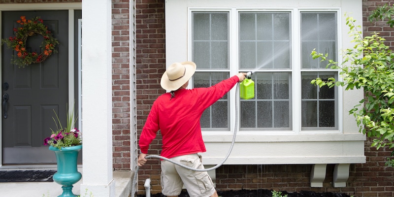 Man Cleaning Exterior of House
